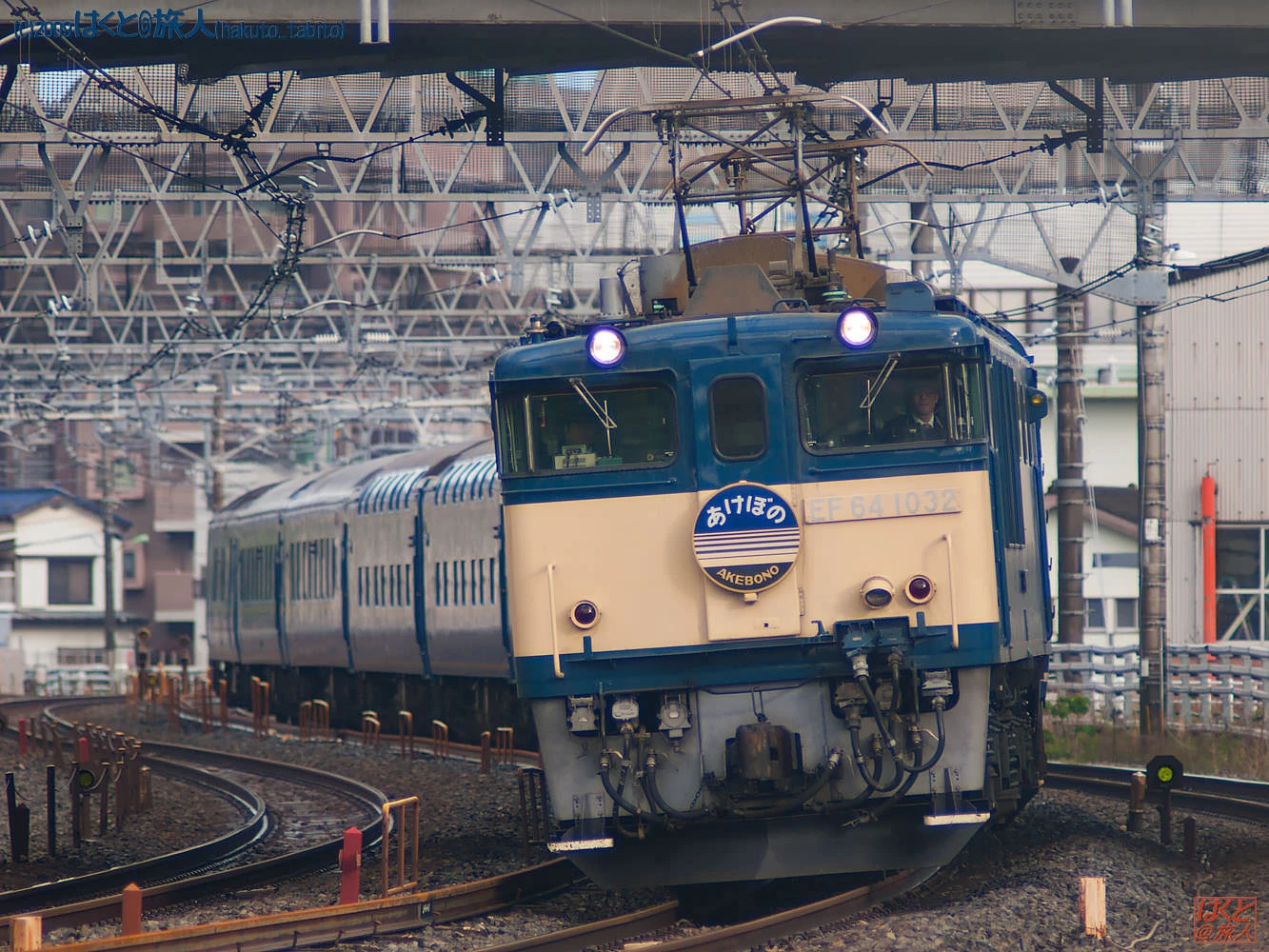 Blue and cream electric locomotive EF64 1032 on a curved track under dense overhead wires, Akebono emblem on its nose.